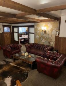 a living room with leather couches and a table at Mon Refuge 111-110 in Bcharré