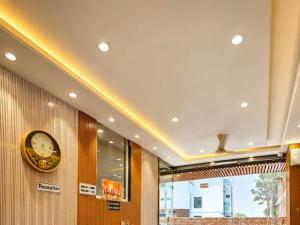 a hallway with a clock on the wall and a window at Hotel Shree Vrindavan Inn in Vrindāvan