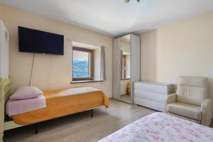 a bedroom with a bed and a television on the wall at Da Dani Casa Vacanza in Pontremoli