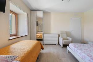 a bedroom with two beds and a chair and a mirror at Da Dani Casa Vacanza in Pontremoli +51 photos