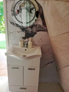 a bathroom with a sink and a mirror on a wall at Drivibe Glamping, Goražde in Goražde