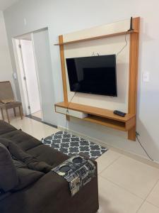 a living room with a flat screen tv on a wall at Apartamento central in Domingos Martins