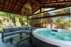 a jacuzzi tub in a patio with a couch at New Horizon Algarve in Almancil