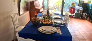 a blue table with plates and a bowl of food on it at KECYHOUSE chambre Légendes in Sevran +11 photos