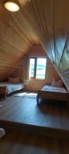 a attic room with two beds and a window at A-Căsuța de la munte in Arieşeni
