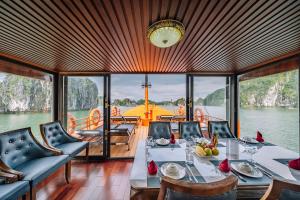a dining room with a table and chairs on a boat at Vietnam Venture Cruises in Cat Ba