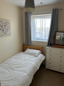 a bedroom with a bed and a window and a dresser at Chestnut 3 in Mablethorpe