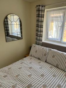 a bedroom with a bed and a mirror and a window at Chestnut 3 in Mablethorpe