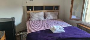 a bedroom with a bed with purple sheets and pillows at KECYHOUSE chambre Légendes in Sevran