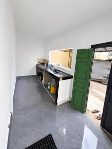 a kitchen with a sink and a green door at Palm Breeze Kokuvil in Jaffna +7 photos