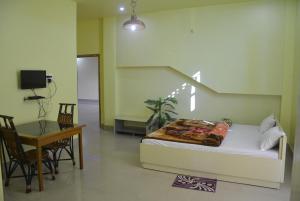 a living room with a bed and a table and a table and chairs at BBL Resort in Bokākhāt +14 photos