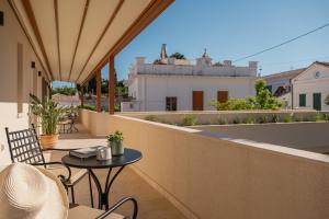 a patio with a table and chairs on a balcony at JUNO Collection Residences in Pythagoreio