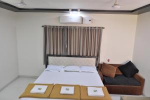 a bedroom with a bed and a couch at Betel Leaf Resort in Māhīm