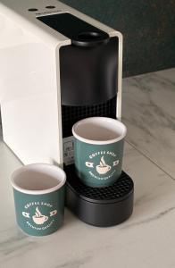 a coffee maker with two cups in a box at TRIO apartment in Piešťany +15 photos