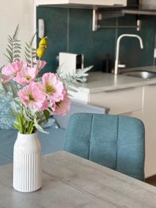 a vase filled with pink flowers on a table at TRIO apartment in Piešťany