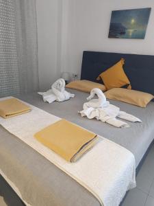 two beds with towels on them with swans on them at Aegean dream house in Ofrínion