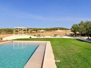 a swimming pool in the middle of a grass field at La Dimora del Pensatore - country escape Noto in Canicattini Bagni