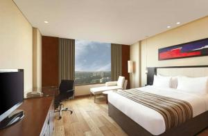 a hotel room with a bed and a desk and a television at Airport Hotel Vella VILLA By Corporate Group Delhi IGI Airport Terminal 3 With Free Airport Pickup in New Delhi