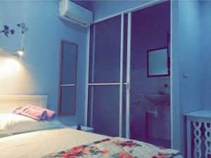 a bedroom with purple walls and a bed and a bathroom at The Second Room in Ranau +21 photos