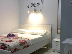 a bedroom with a white bed with a light above it at The Second Room in Ranau