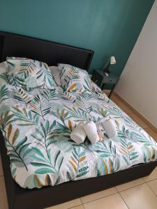 an unmade bed with white slippers on it at Résidence Louis in Saint-Denis