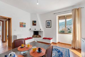 a living room with a table and a fireplace at Ammentos La Casa di Rosa in Orgosolo