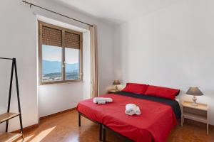 a bedroom with a red bed with a stuffed animal on it at Ammentos La Casa di Rosa in Orgosolo