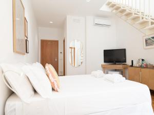a white bedroom with a white bed and a tv at Dadu 14 in Bari