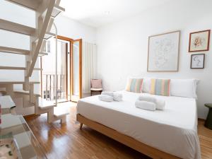 a bedroom with a white bed and a staircase at Dadu 14 in Bari