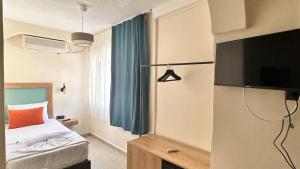 a bedroom with a bed and a television in a room at Minikbiotel in Erdek