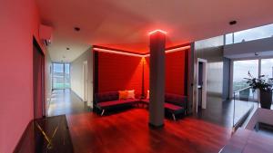 a living room with a red wall and a couch at Mycelio Atlantic Residence with Atlantic View in Ribamar +150 photos