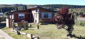 a small house in the middle of a field at CASA Los Tres Picos in Cholila
