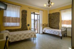 a bedroom with two beds and a stone wall at Agriturismo Finagliosu in Palmadula