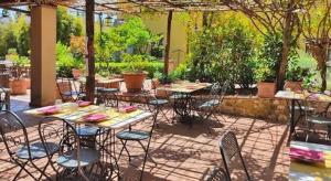 a group of tables and chairs sitting under an umbrella at Hotel Sor Paolo in San Casciano in Val di Pesa