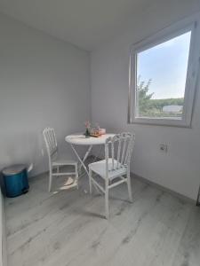 a white table and chairs in a room with a window at Ferma DAC in Galaţi