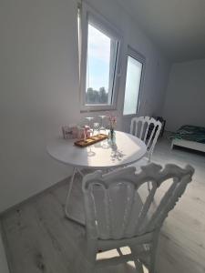 a white table and chairs in a room with a window at Ferma DAC in Galaţi