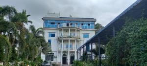 a white building with a balcony on top of it at BBL Resort in Bokākhāt