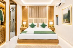 a bedroom with a large bed with green pillows at Hotel Ve Atlantiis Elite in New Delhi