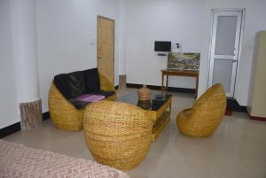 a living room with three wicker chairs and a table at BBL Resort in Bokākhāt