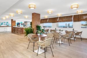 a restaurant with tables and chairs in a room at HSM Sandalo Beach in Magaluf