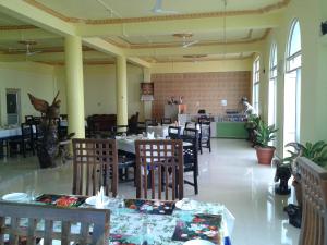 a dining room with tables and chairs in a restaurant at BBL Resort in Bokākhāt