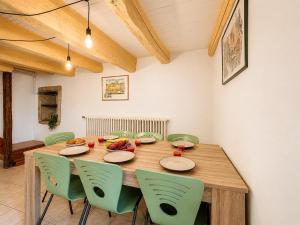 a wooden table with green chairs in a room at Triplex Les Vignes in Vérin