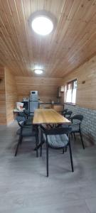 a room with wooden ceilings and tables and chairs at A-Căsuța de la munte in Arieşeni