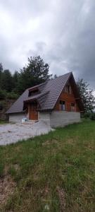 a wooden house with a gambrel roof at A-Căsuța de la munte in Arieşeni