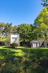 a small house in a field with trees at Camping des Gayeulles in Rennes