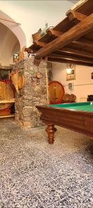 a room with a pool table and a stone fireplace at Relais Casa Spanu in Dorgali
