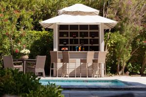 a table and chairs with an umbrella next to a pool at Benvengudo in Les Baux-de-Provence