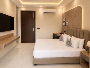 a bedroom with a bed and a flat screen tv at Lime Tree Hotel Golf Course Road, Gurgaon in Gurgaon