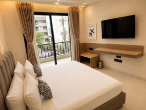 a bedroom with a bed and a flat screen tv at Lime Tree Hotel Golf Course Road, Gurgaon in Gurgaon