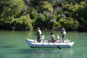 a group of people in a boat on a river at CASA Los Tres Picos in Cholila +1 photo